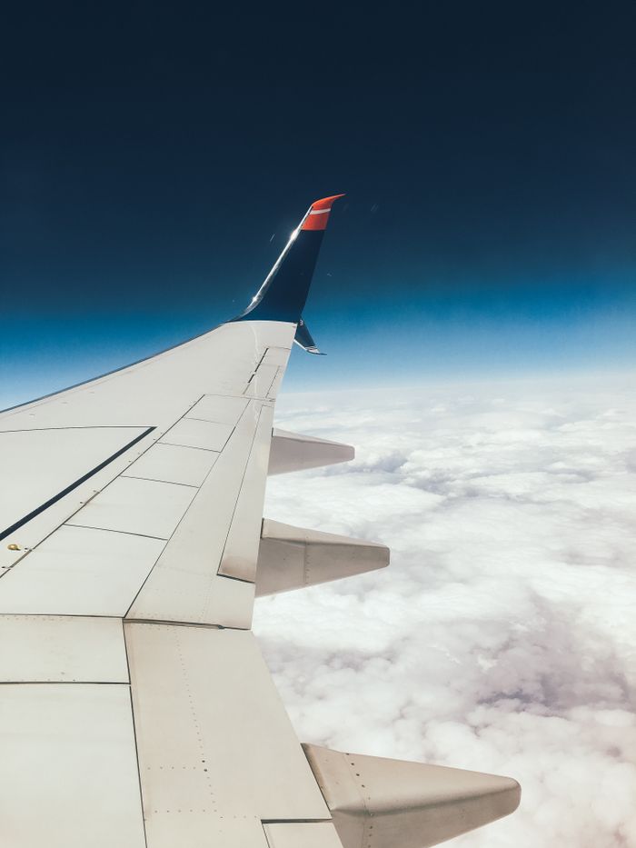 services-06 A serene aerial view from an airplane window with the wing above a sea of clouds.