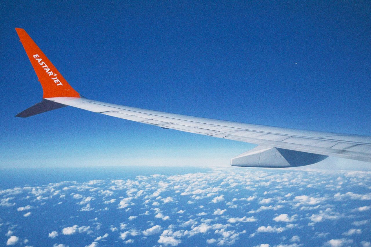 about-hero Scenic view of clouds and airplane wing from Eastar Jet flight over South Korea.