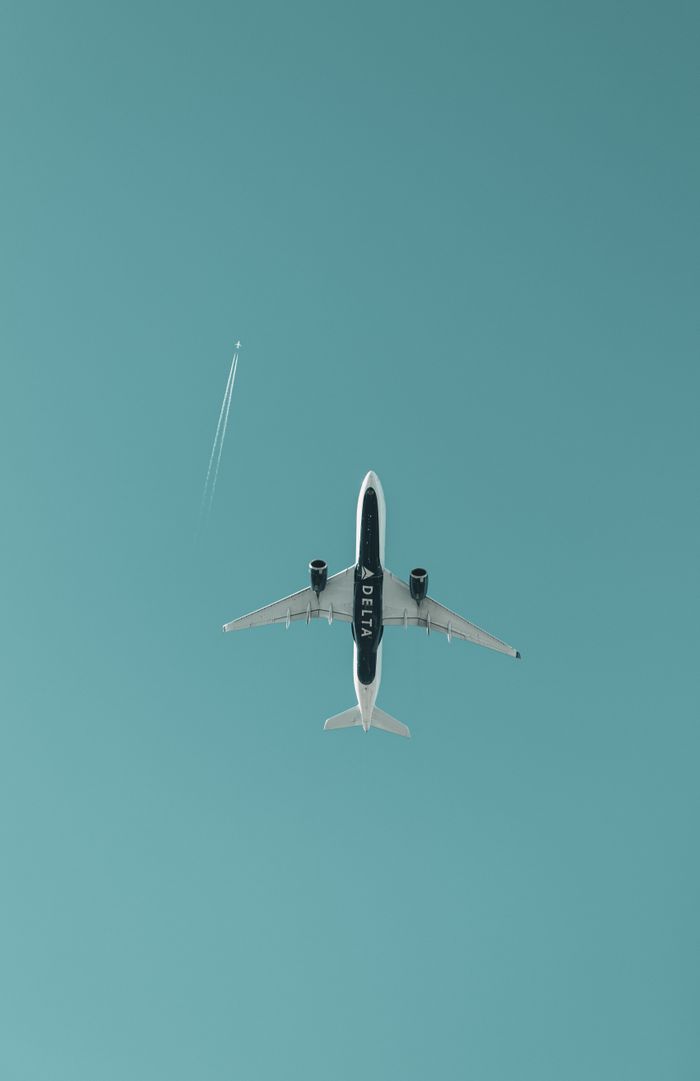services-hero A commercial passenger aircraft soaring through a cloudless blue sky, captured from below.
